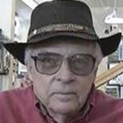 Unsmiling older man with a cowboy hat and tinted glasses